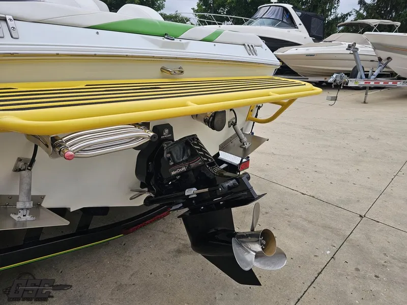 Slide: The Image of 2005 Baja 23 Outlaw boat with yellow accents and MerCruiser engine, docked on concrete. - 35
