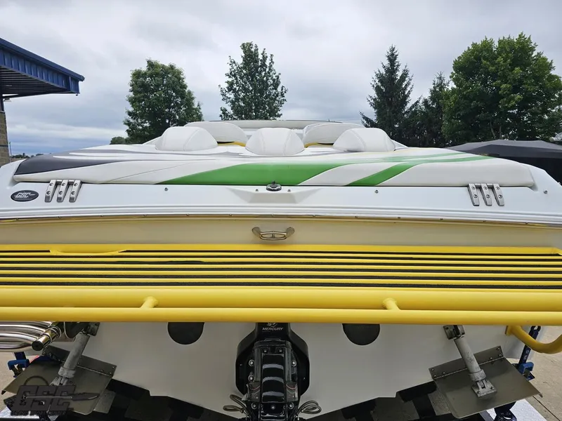 Slide: The Image of 2005 Baja 23 Outlaw boat with vibrant yellow and green accents, parked outdoors. - 39