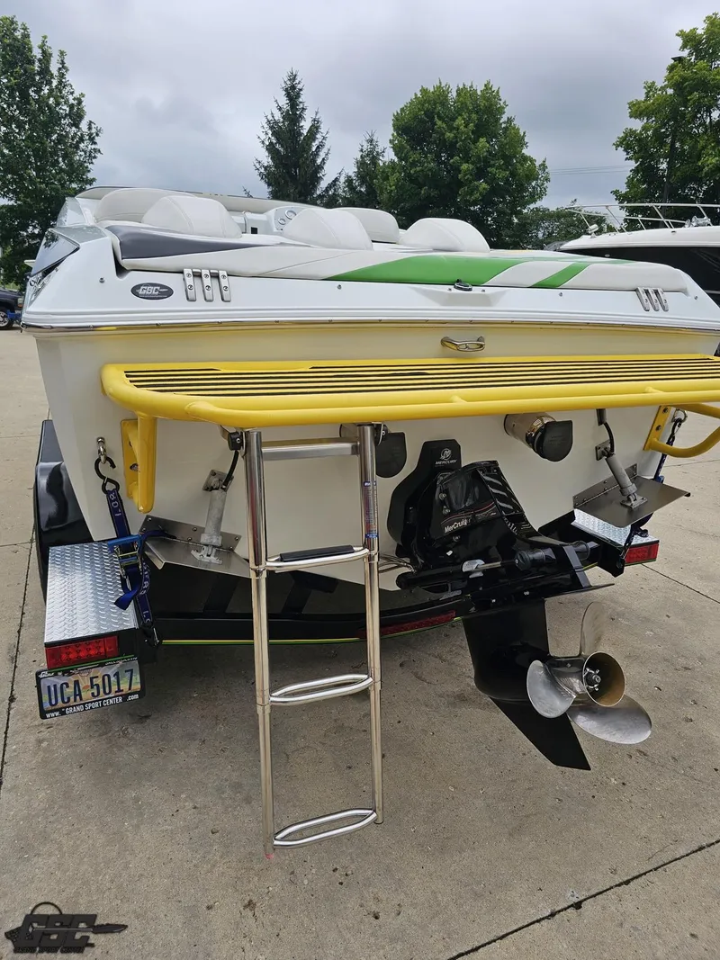 Slide: The Image of 2005 Baja 23 Outlaw boat with yellow swim platform and ladder, parked on a trailer. - 41