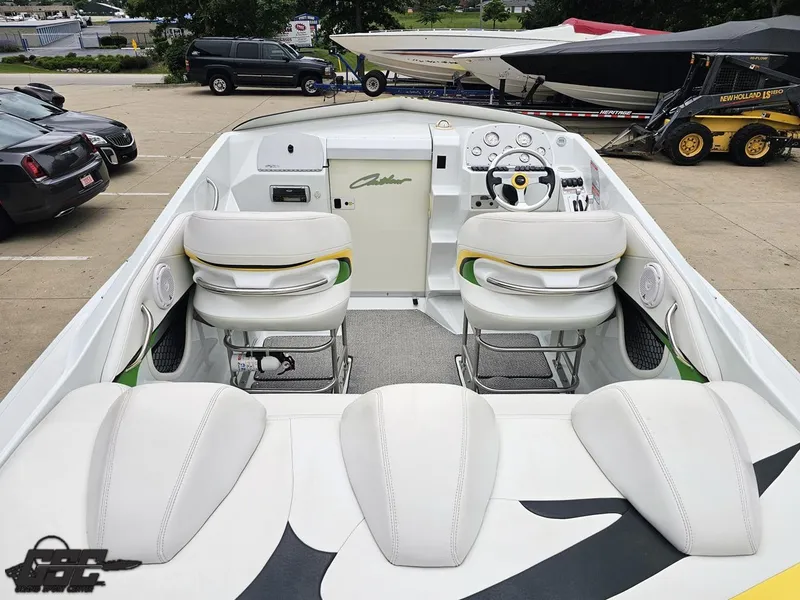 Slide: The Image of 2005 Baja 23 Outlaw boat interior with white seating and dashboard, parked in a lot. - 47