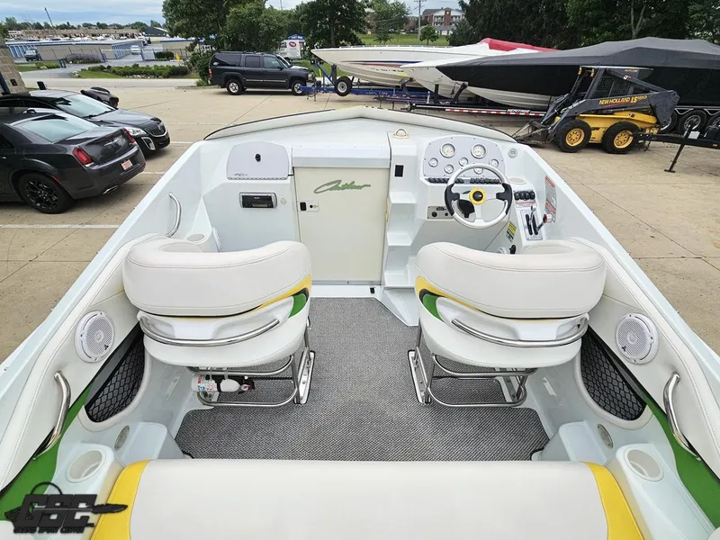 Slide: The Image of 2005 Baja 23 Outlaw boat interior with white seating and dashboard, parked outdoors. - 48