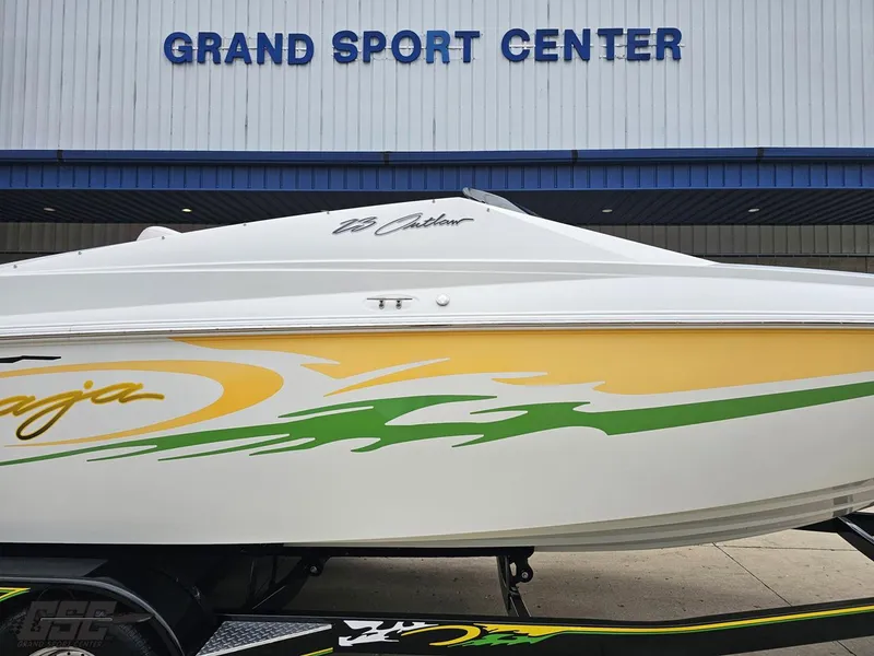 Slide: The Image of 2005 Baja 23 Outlaw boat at Grand Sport Center, featuring vibrant yellow and green graphics. - 6