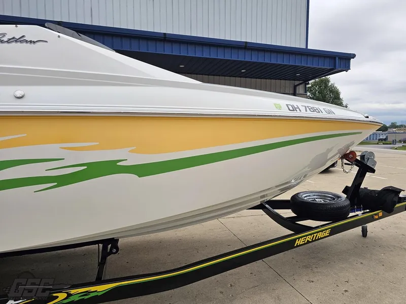 Slide: The Image of 2005 Baja 23 Outlaw boat with yellow and green design on a trailer. - 7