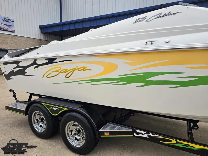 Slide: The Image of 2005 Baja 23 Outlaw boat with vibrant graphics on a trailer. - 8