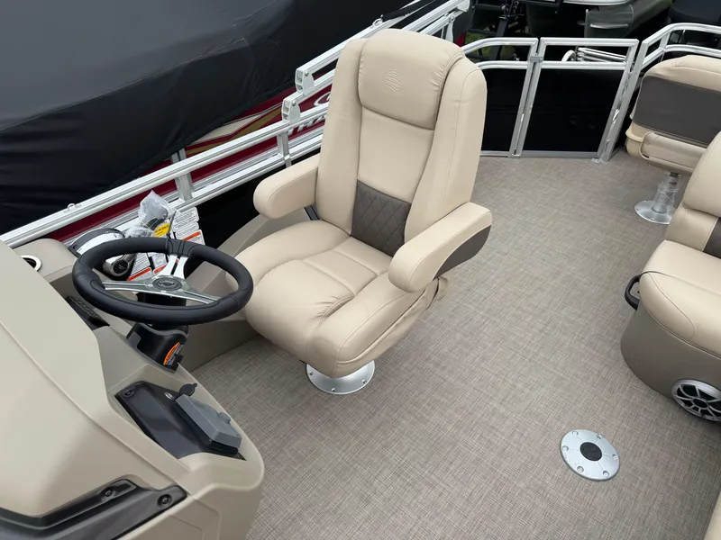 Slide: The Image of 2025 Sun Tracker SportFish 22 XP3 boat interior with beige captain's chair and steering console. - 10
