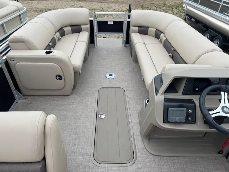 Slide: The Image of 2025 Sun Tracker SportFish 22 XP3 pontoon boat interior with beige seating and steering console. - 19