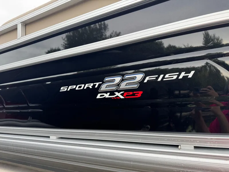 Slide: The Image of 2025 Sun Tracker SportFish 22 XP3 boat logo on black exterior. - 3