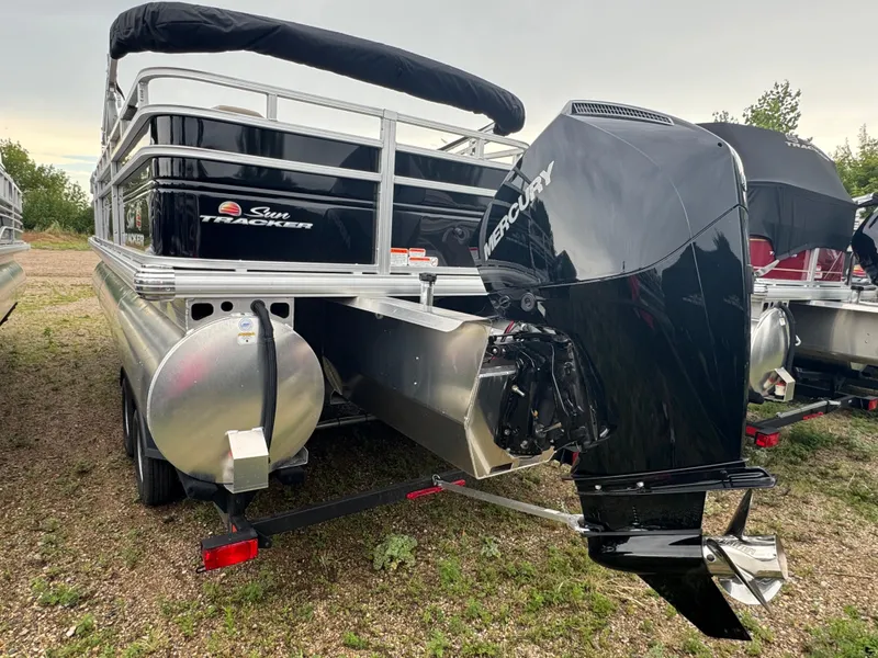 Slide: The Image of 2025 Sun Tracker SportFish 22 XP3 pontoon boat with Mercury outboard motor, parked on grass. - 5