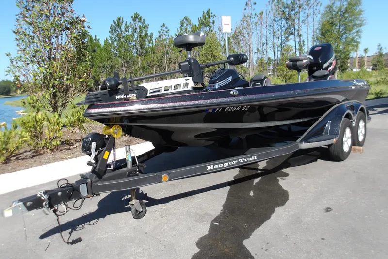 Slide: The Image of 2017 Ranger Z518c fishing boat on trailer, parked near a lake with trees in the background. - 3