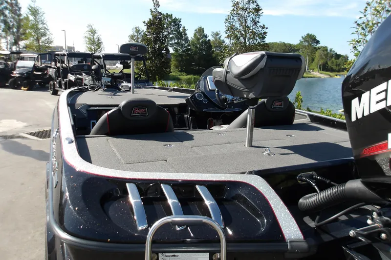 Slide: The Image of 2017 Ranger Z518c boat with Mercury engine, parked near a lake, surrounded by trees. - 4