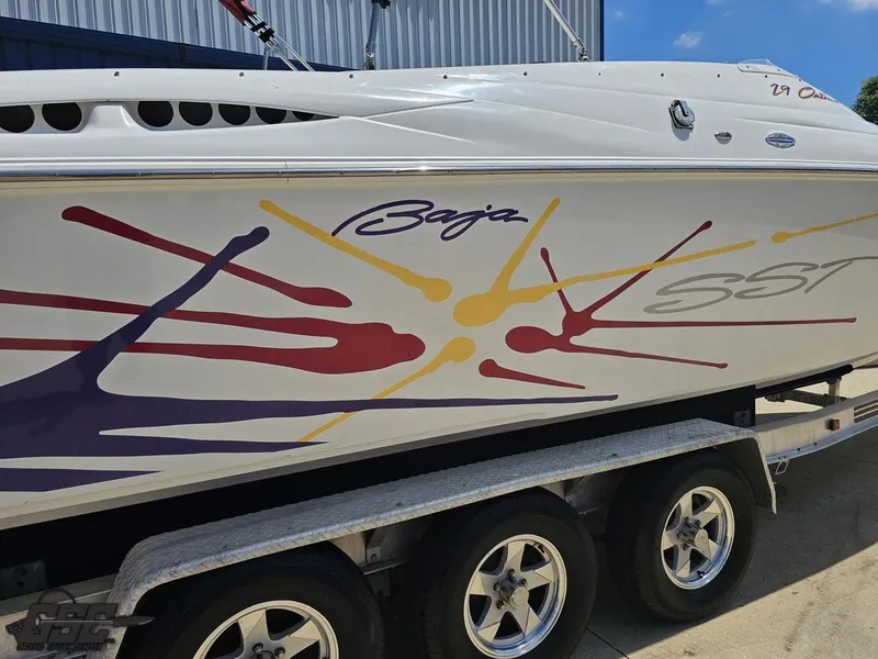 Slide: The Image of 2000 Baja 29 Outlaw boat with colorful graphics on a trailer. - 15