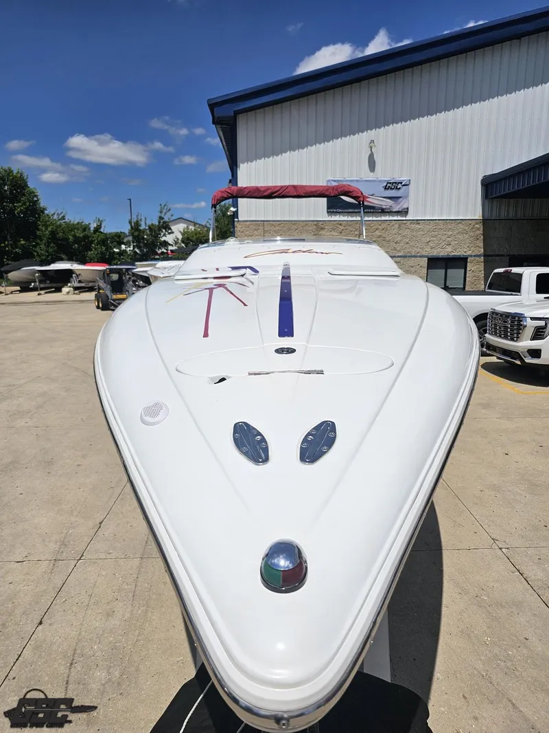Slide: The Image of 2000 Baja 29 Outlaw boat parked outdoors under a clear blue sky. - 20