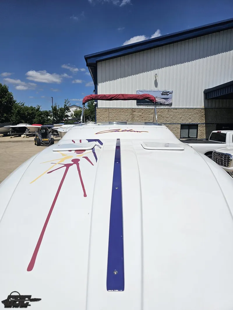 Slide: The Image of 2000 Baja 29 Outlaw boat with colorful graphics, parked outdoors under a clear blue sky. - 21