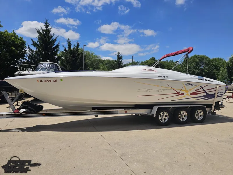 Slide: The Image of 2000 Baja 29 Outlaw speedboat on trailer, vibrant graphics, sunny day, trees in background. - 25