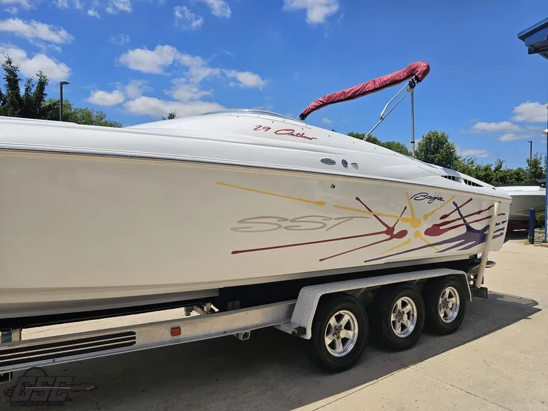 Slide: The Image of 2000 Baja 29 Outlaw boat on trailer under blue sky. - 26