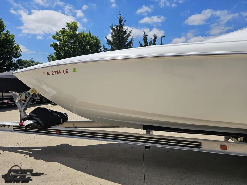 Slide: The Image of 2000 Baja 29 Outlaw boat on trailer under a clear blue sky. - 27