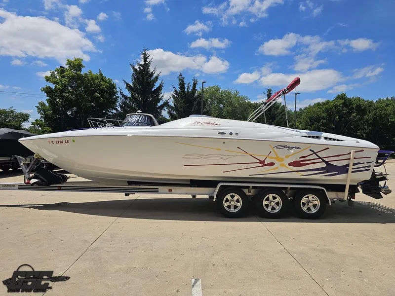 Slide: The Image of 2000 Baja 29 Outlaw speedboat on trailer, vibrant graphics, sunny day, parked outdoors. - 29