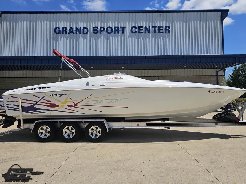 Slide: The Image of 2000 Baja 29 Outlaw boat on trailer at Grand Sport Center, clear sky background. - 3