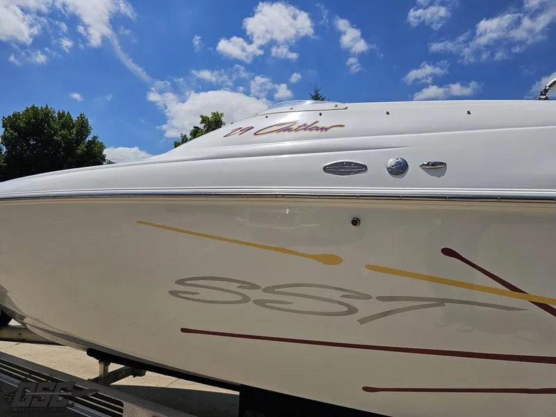 Slide: The Image of 2000 Baja 29 Outlaw boat with sleek design and vibrant graphics under a clear blue sky. - 32