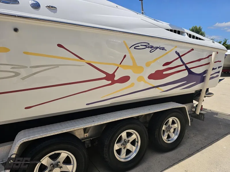 Slide: The Image of 2000 Baja 29 Outlaw boat with colorful graphics on a trailer. - 35