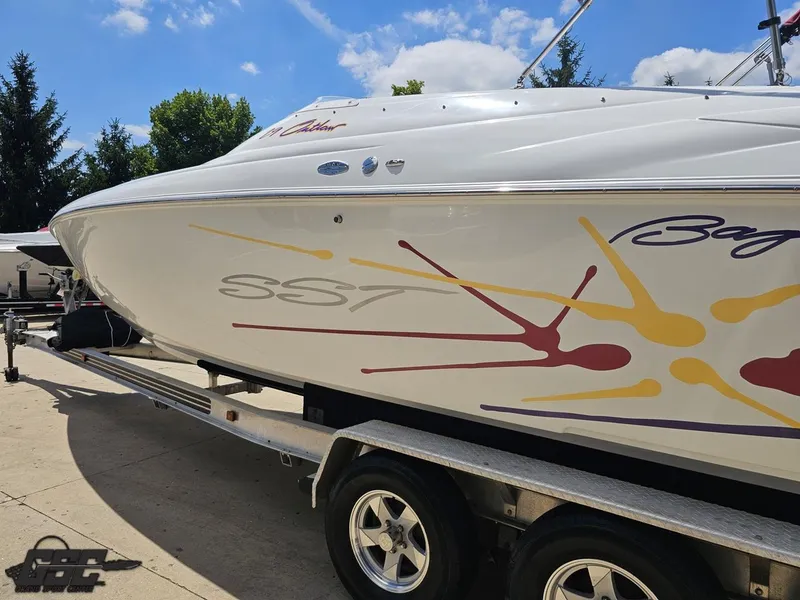 Slide: The Image of 2000 Baja 29 Outlaw boat on trailer, featuring colorful graphics under a clear blue sky. - 37