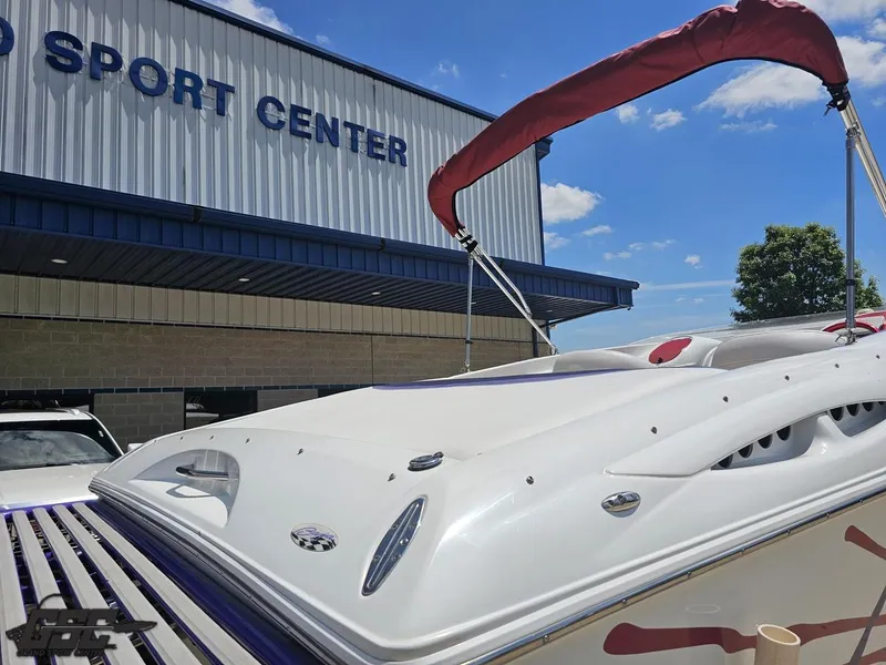 Slide: The Image of 2000 Baja 29 Outlaw boat at a sport center, under a clear blue sky. - 46