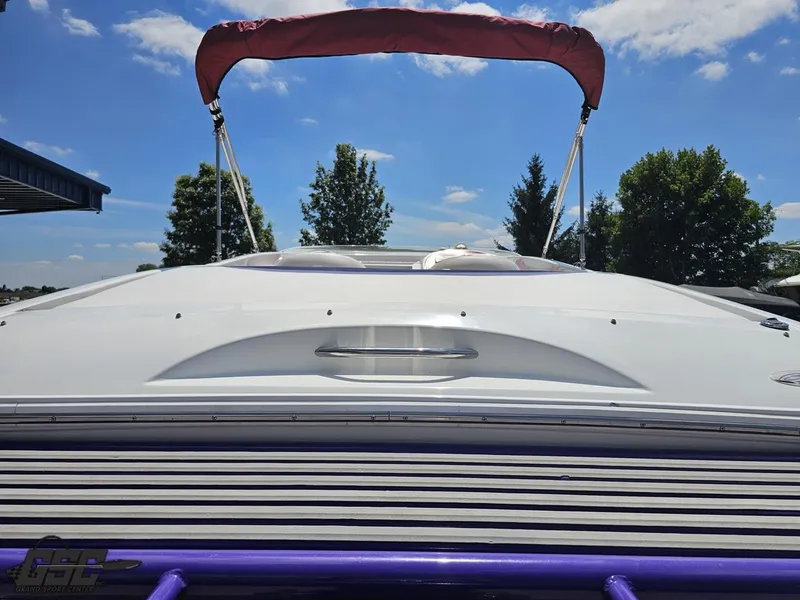 Slide: The Image of 2000 Baja 29 Outlaw boat with red canopy, viewed from the rear under a clear blue sky. - 48