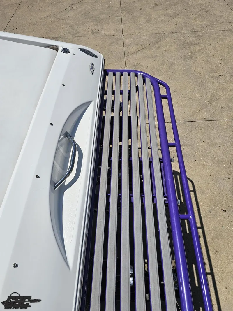 Slide: The Image of 2000 Baja 29 Outlaw boat with purple railing on concrete surface. - 49