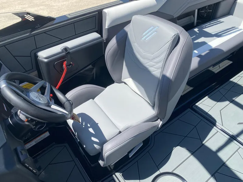 Slide: The Image of 2025 ATX Surf Boats 24 Type-S interior with steering wheel and captain's seat. - 7