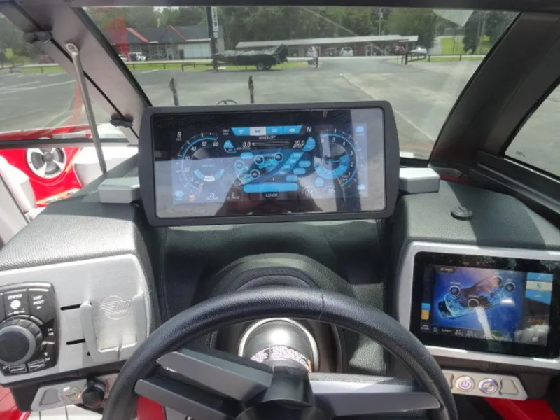 Slide: The Image of Dashboard of a 2018 Malibu 23 LSV boat with digital displays and steering wheel. - 10