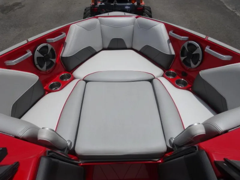 Slide: The Image of 2018 Malibu 23 LSV boat interior with red and gray seating, cup holders, and speakers. - 11
