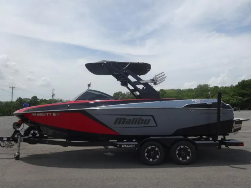 Slide: The Image of 2018 Malibu 23 LSV boat on trailer, red and gray design, parked outdoors. - 4