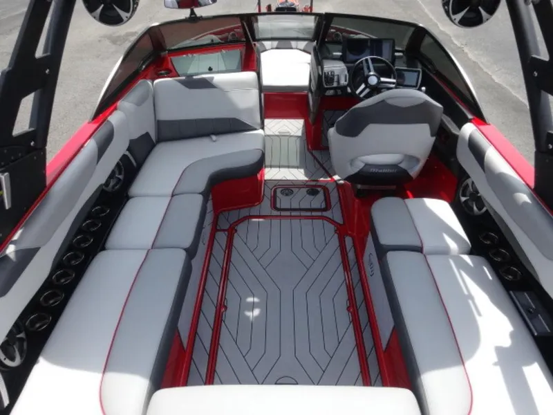 Slide: The Image of 2018 Malibu 23 LSV boat interior with red and gray seating, modern dashboard, and spacious layout. - 6