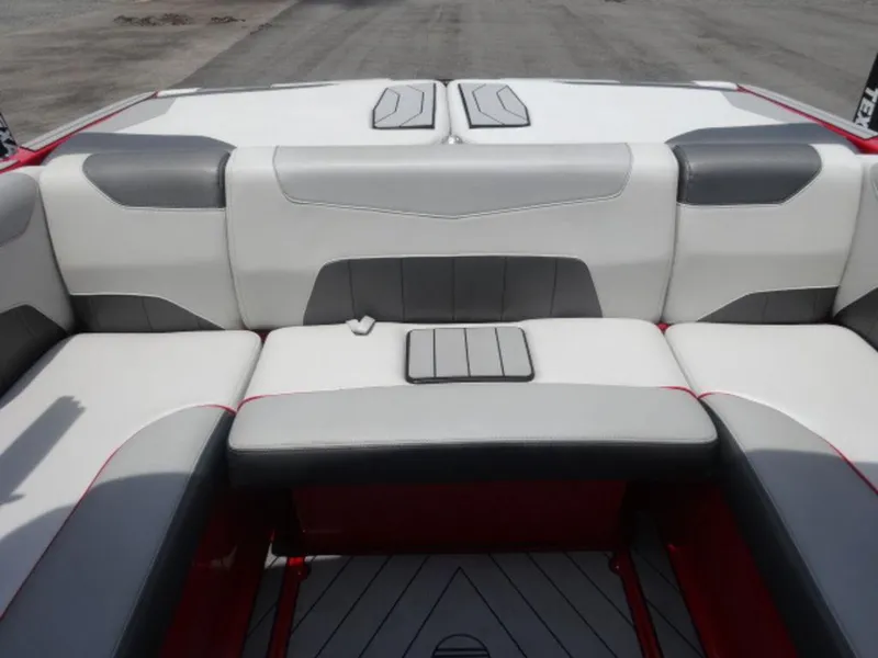 Slide: The Image of 2018 Malibu 23 LSV boat interior with gray and white seating, red accents. - 9