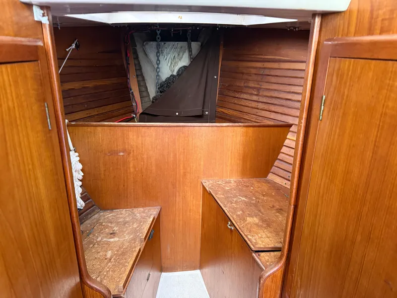 Slide: The Image of Interior of 1984 Aloha 32 sailboat with wooden cabinetry and storage compartments. - 10