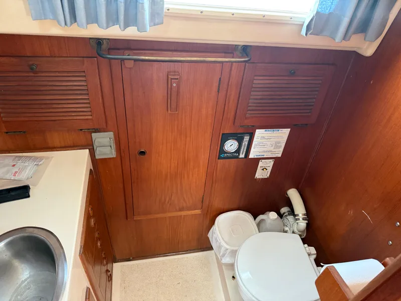 Slide: The Image of 1984 Aloha 32 yacht bathroom with wooden cabinetry, sink, and toilet. - 11