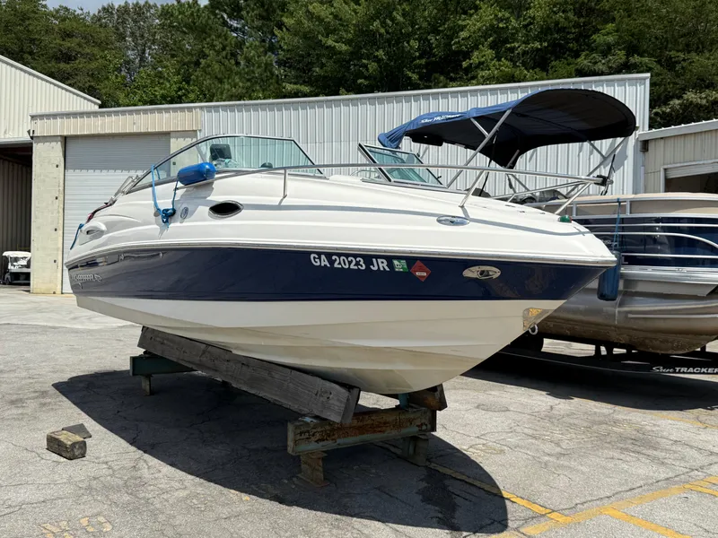 The Image of 2007 Chaparral 215 SSi boat on a stand, parked outdoors near a warehouse. - 0