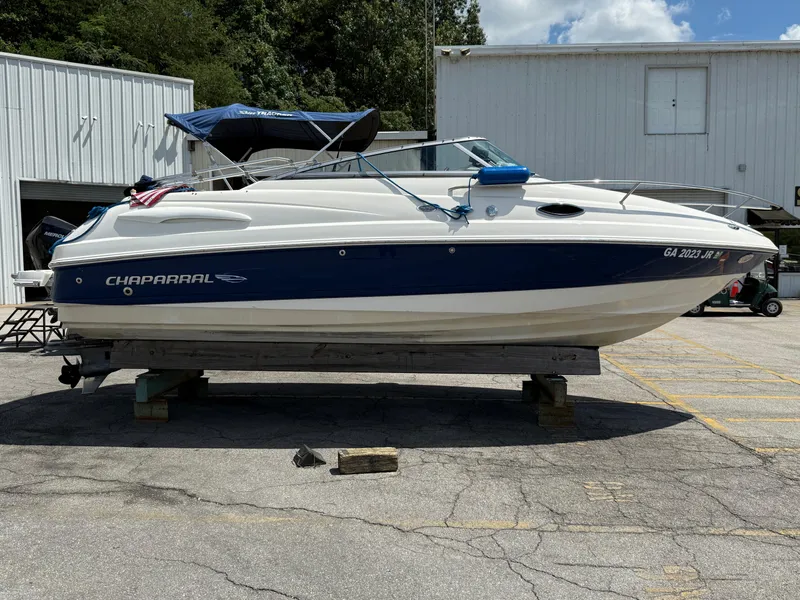 Slide: The Image of 2007 Chaparral 215 SSi boat on display, blue and white exterior, parked outdoors. - 1