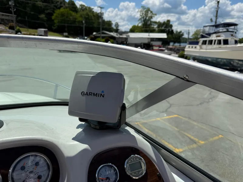 Slide: The Image of 2007 Chaparral 215 SSi boat dashboard with Garmin GPS, docked under a sunny sky. - 13