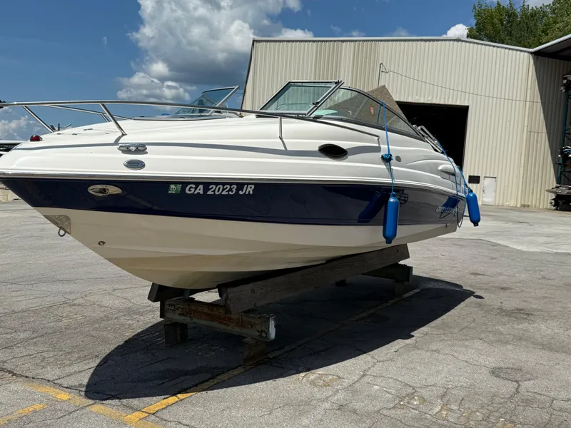 Slide: The Image of 2007 Chaparral 215 SSi boat on a stand, outside a warehouse under a blue sky. - 2