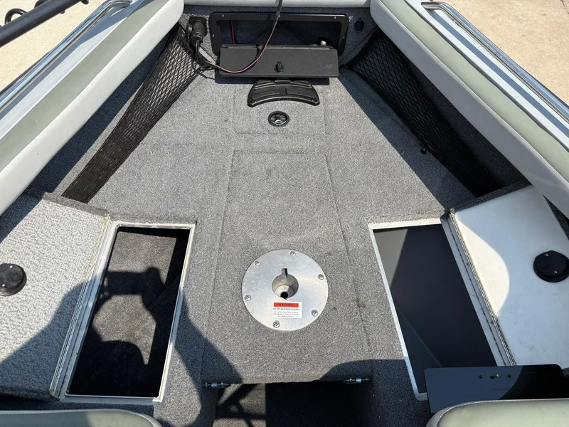 Slide: The Image of Interior of a 2001 Lund 1950 Tyee Magnum GS ITS boat, featuring carpeted flooring. - 15