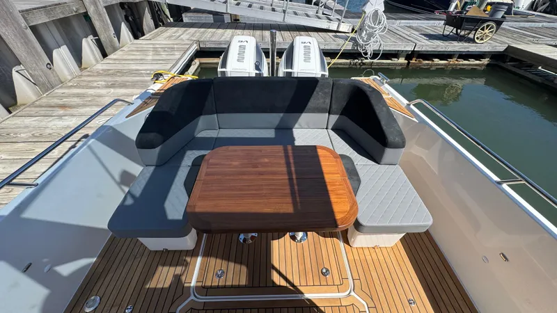 Slide: The Image of Luxurious seating area on a 2025 Nimbus T9 boat, featuring a wooden table and cushioned seats. - 16