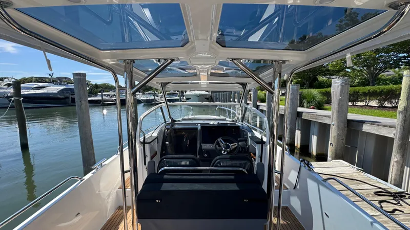 Slide: The Image of Modern Nimbus T9 boat interior, 2025 model, docked at a marina with clear skies. - 17