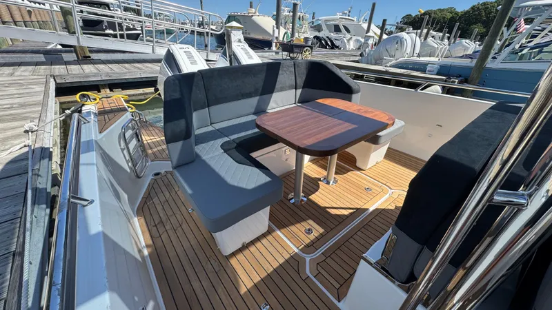 Slide: The Image of Luxurious Nimbus T9 boat interior with wooden deck and cushioned seating, docked at a marina. - 20
