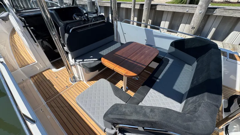 Slide: The Image of Luxurious seating area on 2025 Nimbus T9 boat with wooden table and cushioned seats. - 21