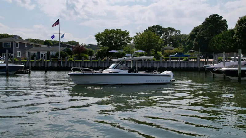 Slide: The Image of A Nimbus T9 boat from 2025 cruising on a calm waterfront near a residential area. - 3