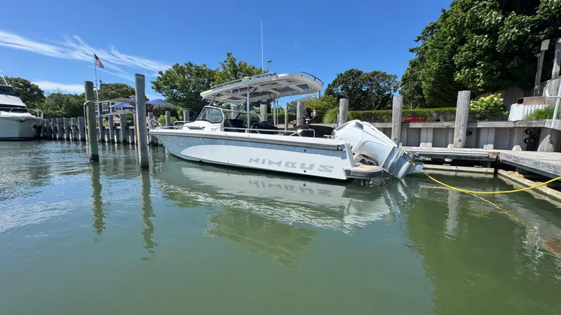 Slide: The Image of Nimbus T9 2025 boat docked in a serene marina under a clear blue sky. - 8