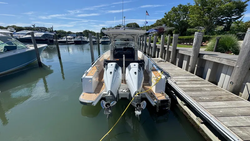 Slide: The Image of 2025 Nimbus T9 boat docked at marina with dual outboard engines. - 10