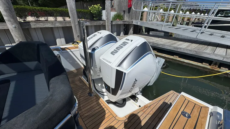 Slide: The Image of Twin Mercury outboard engines on a 2025 Nimbus T9 boat docked at a marina. - 14