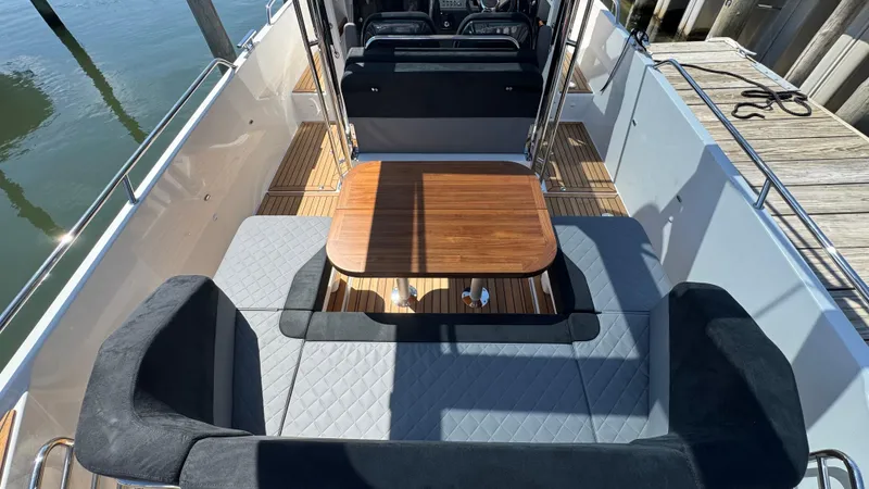 Slide: The Image of 2025 Nimbus T9 boat interior with wooden table and cushioned seating. - 15